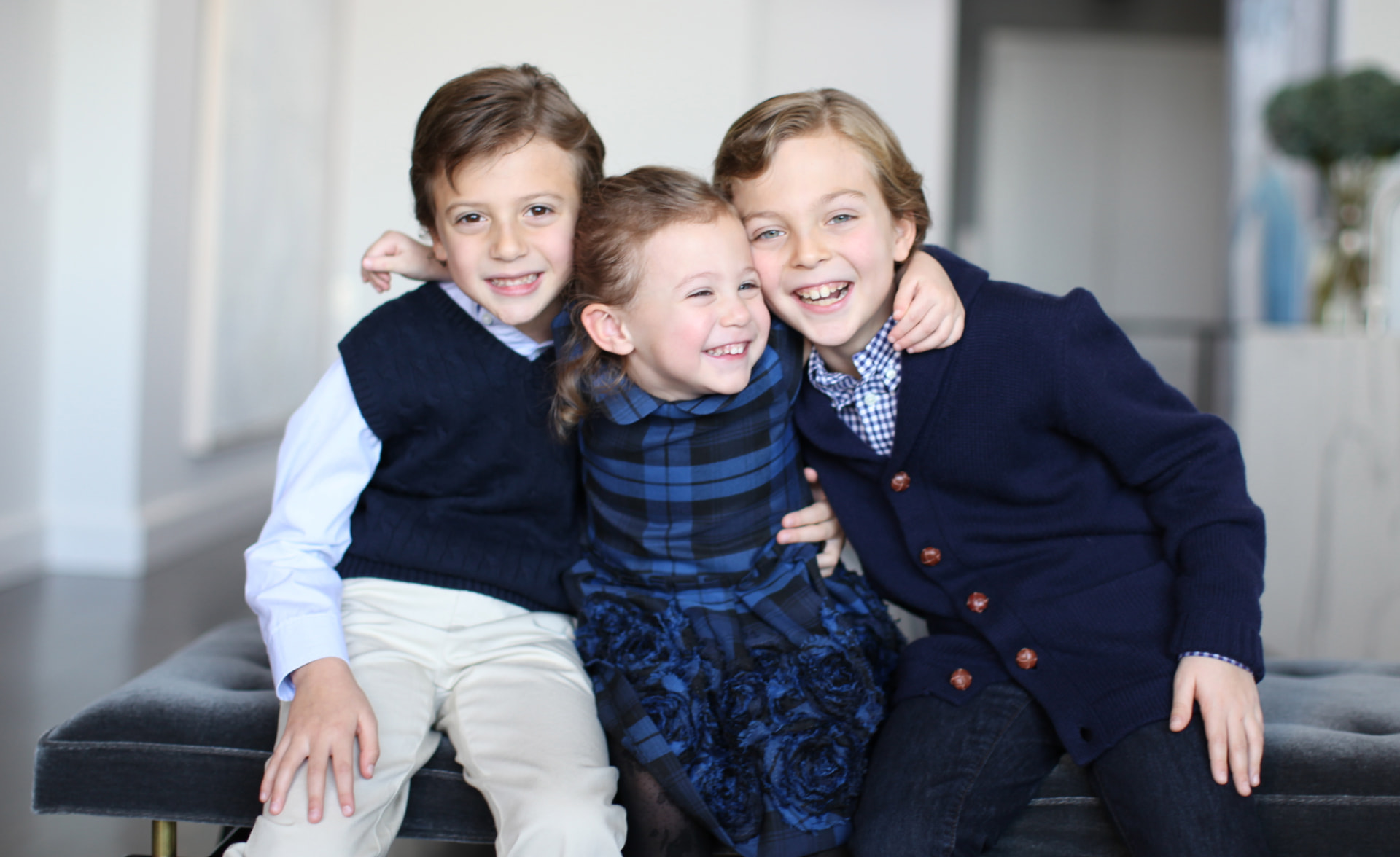 Stella and her brothers sitting together on a sofa